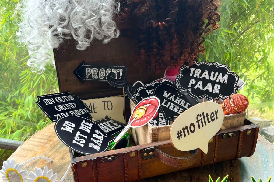 Verschiedene Fotobox-Requisiten wie Perücken und Schilder beim 25. Jubiläum der 1000hands AG für Spaß und Erinnerungsfotos.